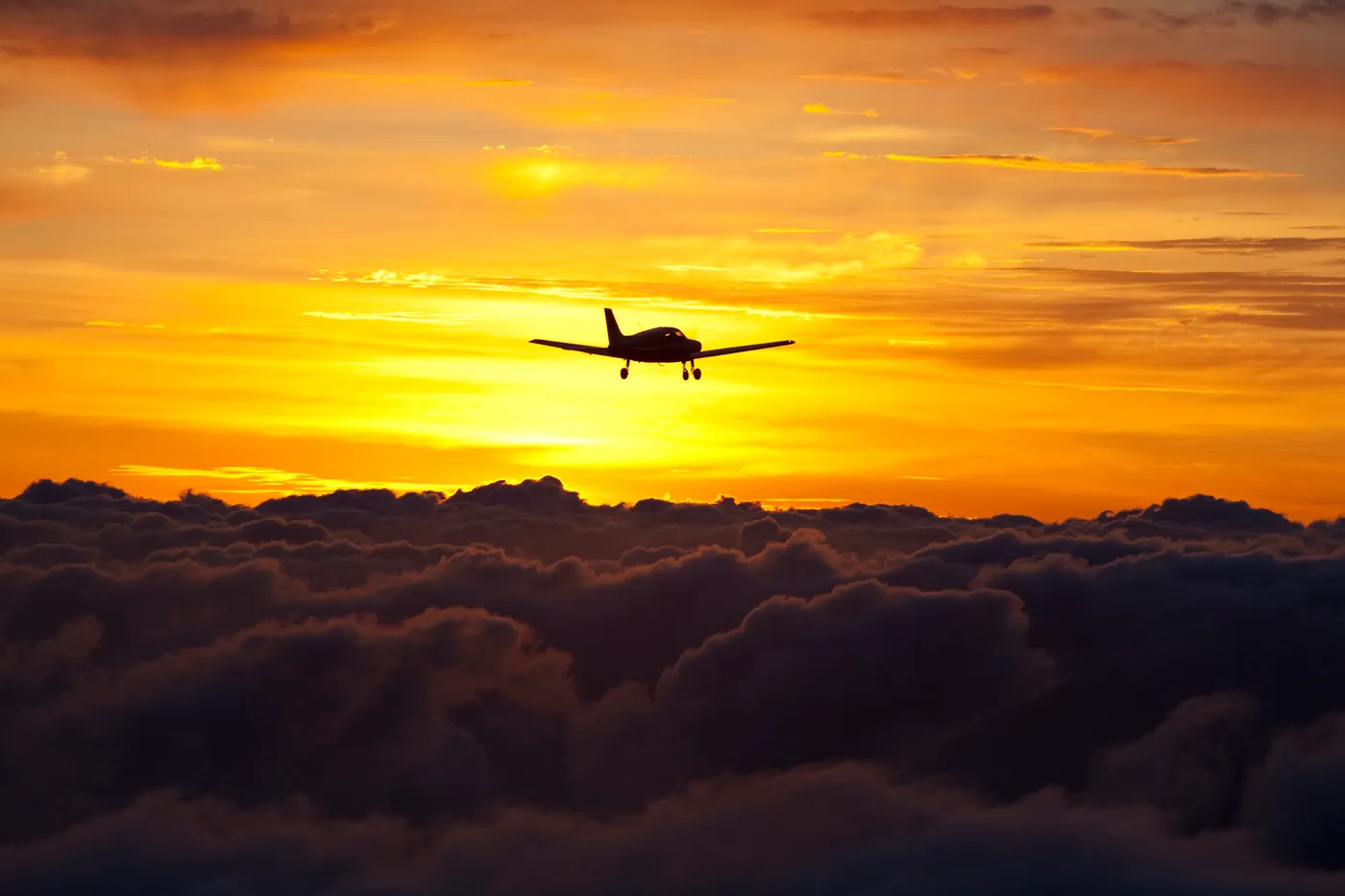 Plane flying through the sky during sunset