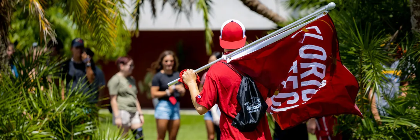 Student Holding Florida Tech Flag on College Colors Day