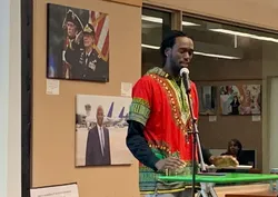 Guest speaker at past event with images behind him.